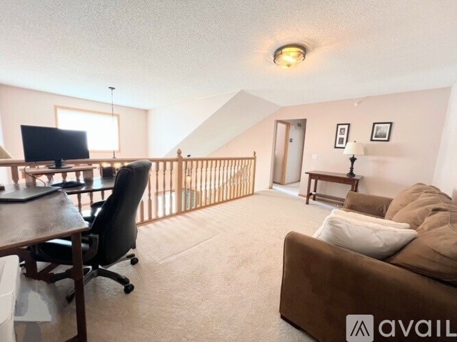 A living room with a brown couch, a black chair, and a television.