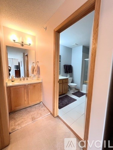 A bathroom with a mirror and a wooden cabinet.