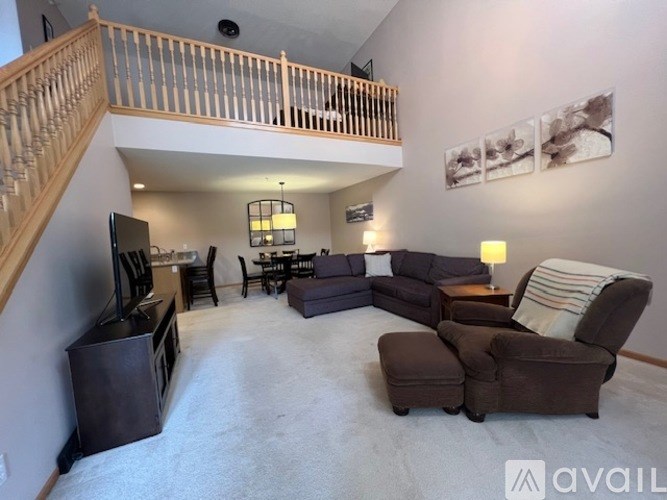 A living room with a staircase and a television.