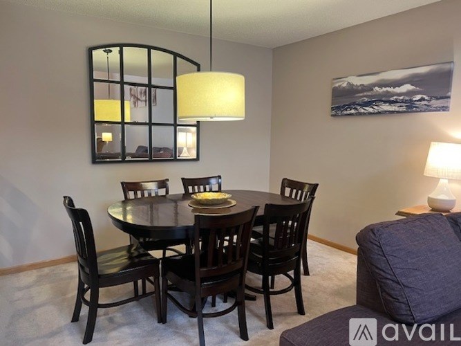 A dining room with a round table and chairs.