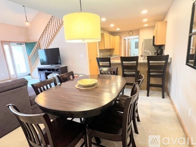 A dining room with a wooden table and chairs.