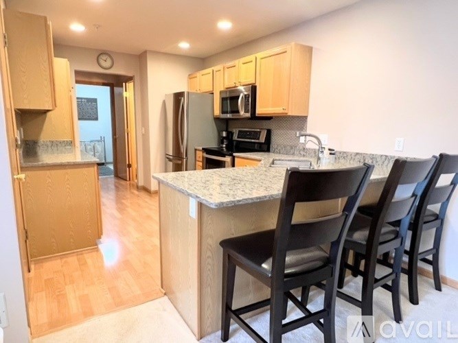 A kitchen with a granite countertop and wooden cabinets.