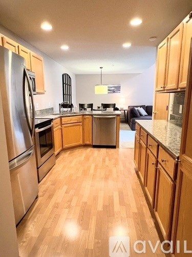 A kitchen with wooden floors and stainless steel appliances.