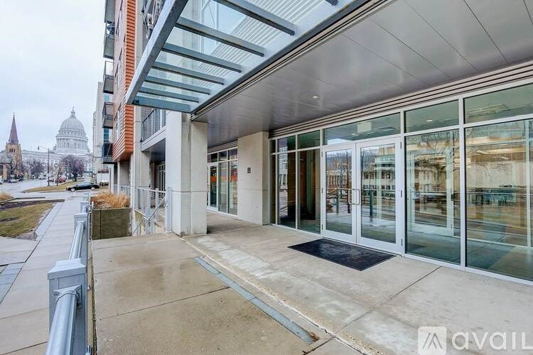 A building with a glass facade and a metal railing in front.