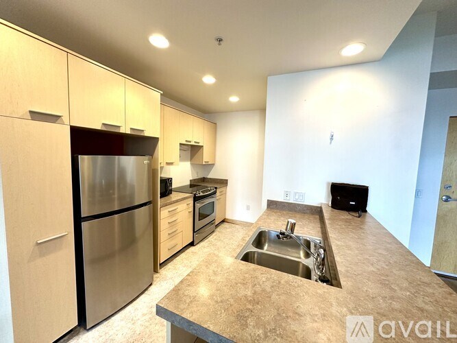 A kitchen with a sink, refrigerator, and oven.