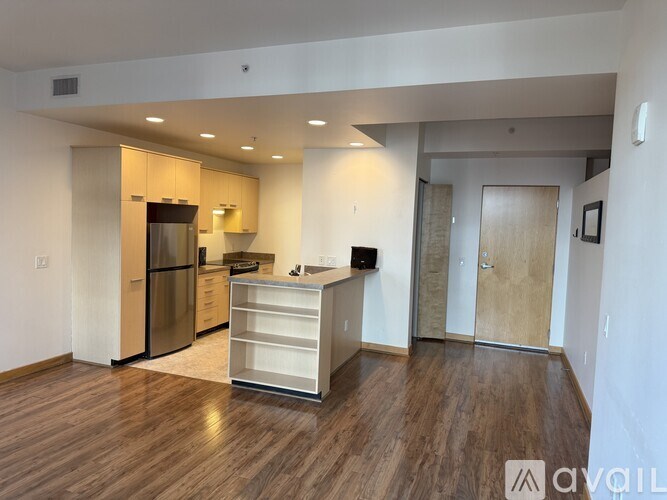 A kitchen with wooden floors and a refrigerator.