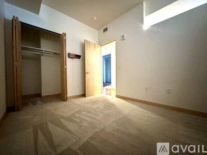 A carpeted room with a door open to a hallway.