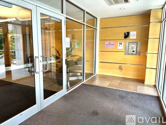 A hallway with a glass door and a carpeted floor.