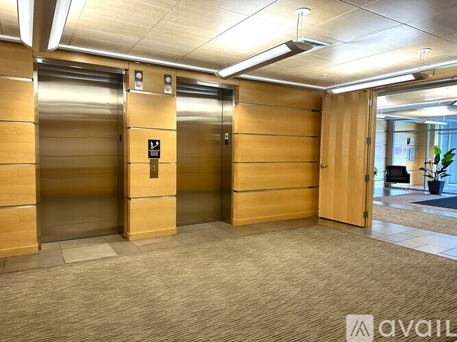 Two elevators in a hallway with a sign on the wall.