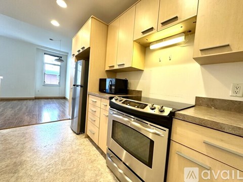 A kitchen with a stove top oven and a refrigerator.