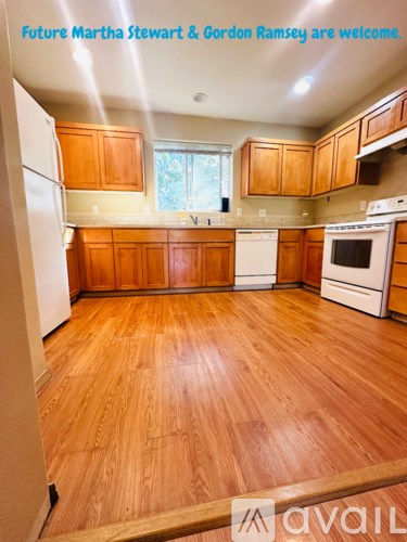 A kitchen with wooden floors and cabinets is shown.