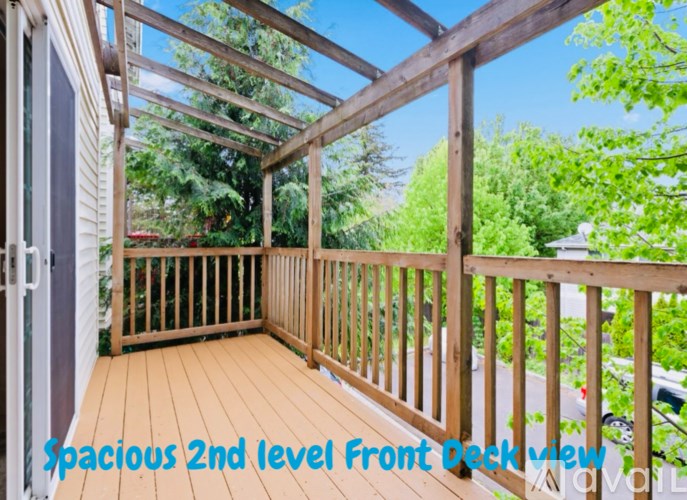 A wooden deck with a glass roof and a view of the trees.