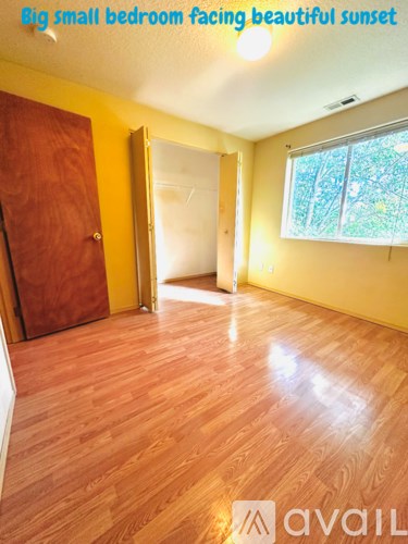 A room with wooden flooring and a window.