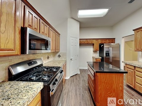 A kitchen with wooden cabinets and a granite countertop.
