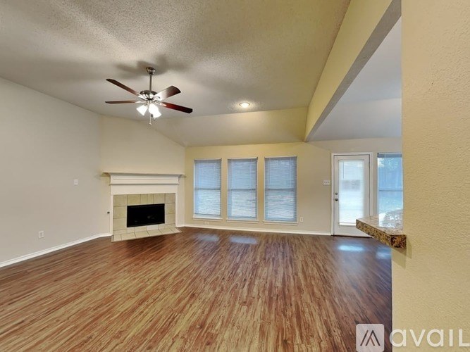 A room with a fireplace and wood flooring.