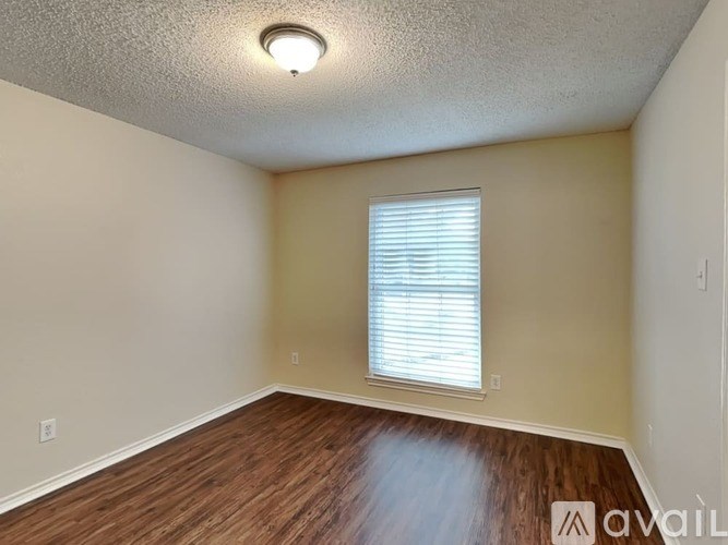 A room with a window and wooden flooring.