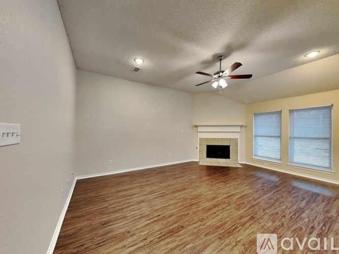 A room with a fireplace and a ceiling fan.