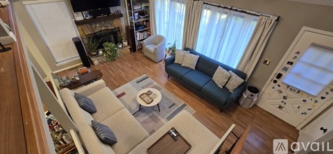 A living room with a blue couch and a fireplace.