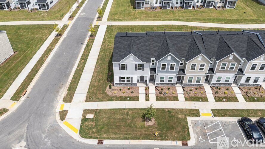 A row of houses with a road in front of them.