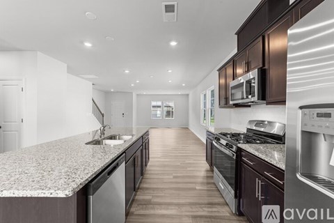 A modern kitchen with dark wood cabinets and stainless steel appliances.