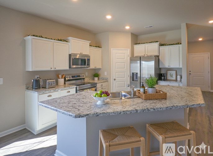 A kitchen with a granite countertop and white cabinets.