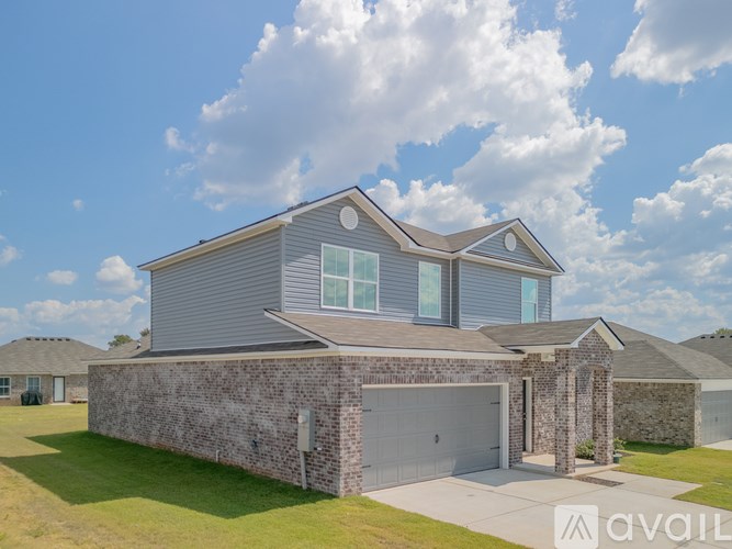 A modern house with a grey roof and a stone wall.