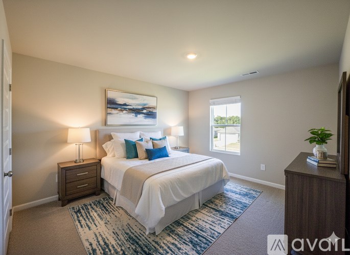 A bedroom with a bed, nightstand, and a window.