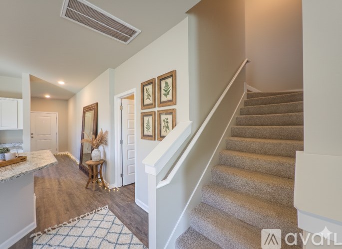 A staircase with a beige carpet and a white railing.