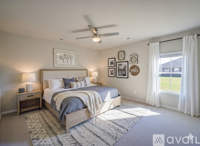 A well-lit bedroom with a large bed and a ceiling fan.