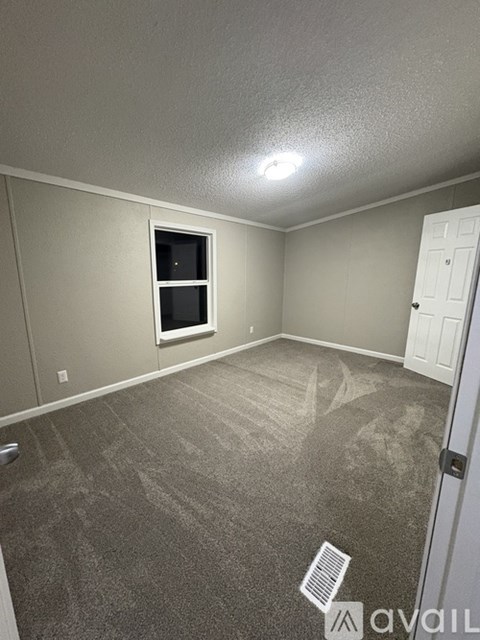 A room with a carpeted floor and a window.