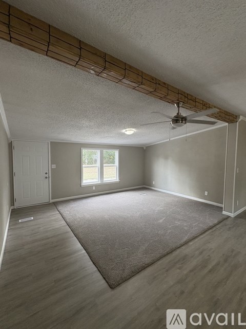 A room with a ceiling fan and a window.