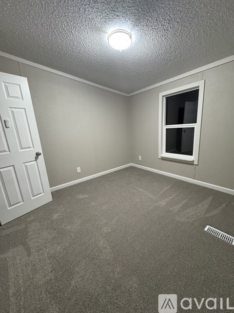 A room with a door, window, and carpeted floor.