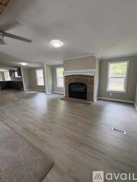 A living room with a fireplace and a ceiling fan.
