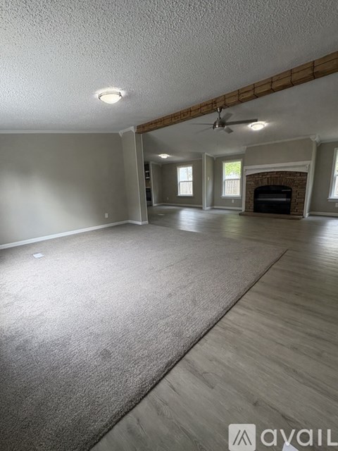 A living room with a fireplace and a ceiling fan.