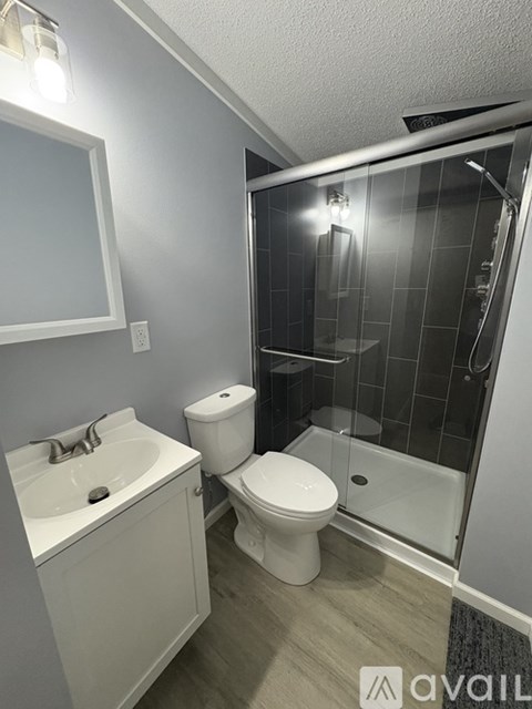 A bathroom with a toilet, sink, and shower.