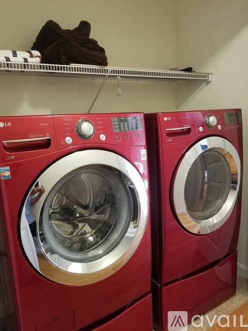 Two red LG front load washing machines in a laundry room.