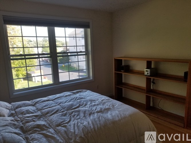 A bedroom with a large bed and a window overlooking a street.