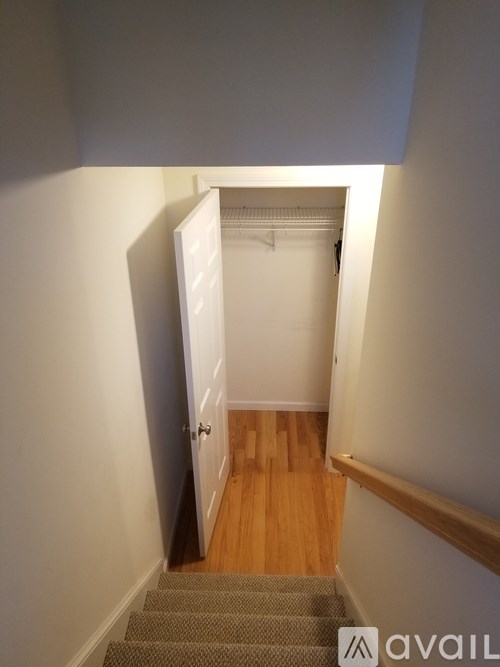 A hallway with a wooden floor and a white door.