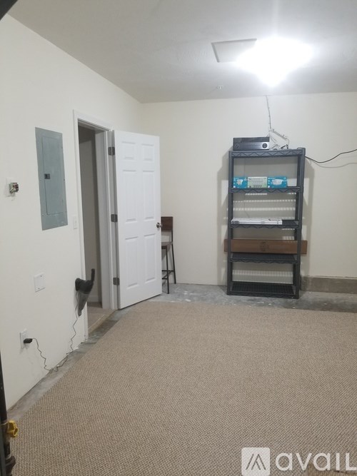 A room with a door and a shelf with a flat screen TV on it.
