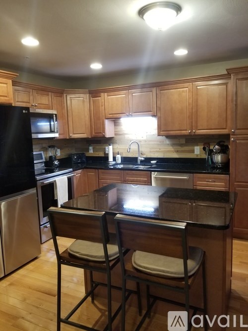 A kitchen with wooden cabinets and black appliances.