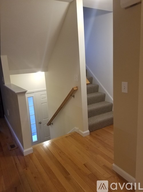 A hallway with a staircase leading to the second floor.