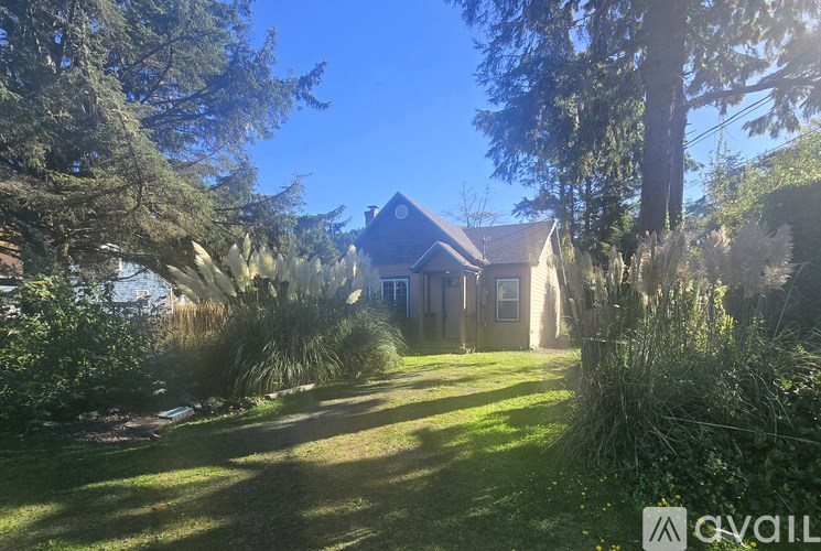 A house surrounded by greenery under a clear blue sky.