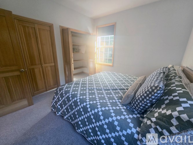 A bedroom with a large bed and a window.