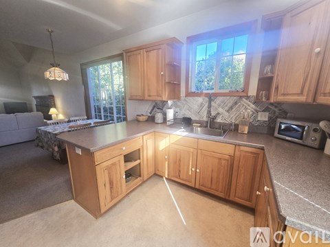 A kitchen with wooden cabinets and a marble countertop.