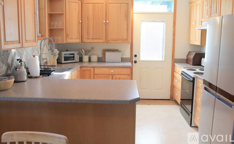 A kitchen with wooden cabinets and a white door.