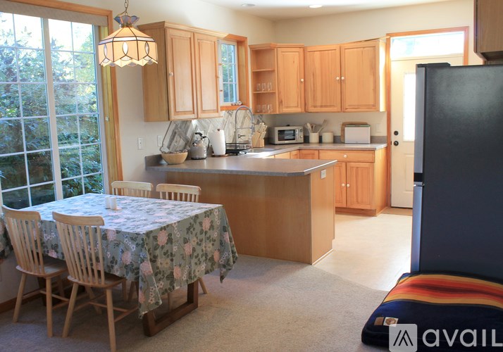A kitchen with wooden cabinets and a table set for two.
