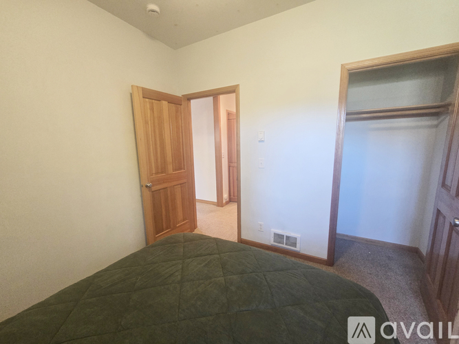 A bedroom with a bed and a door.
