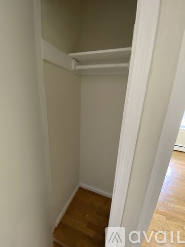 A room with a white wall and wooden floor.