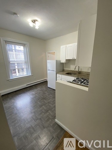 A kitchen with a refrigerator, sink, and cabinets.