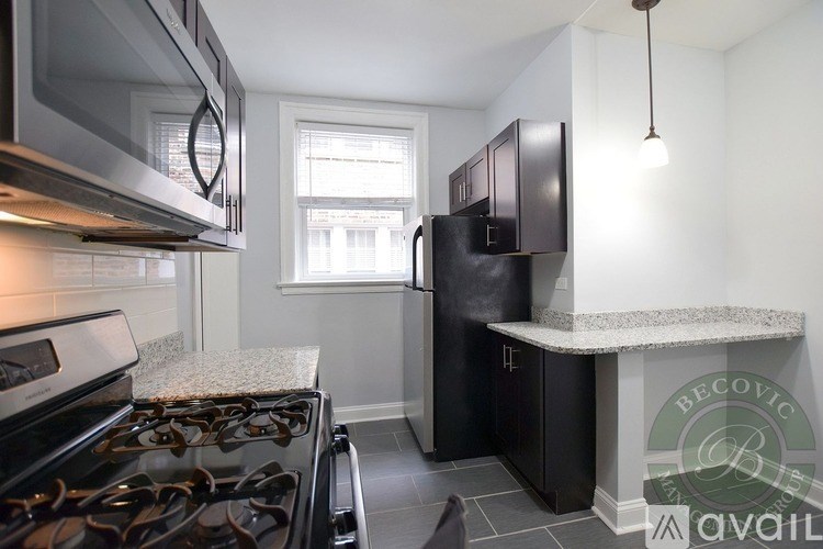 A kitchen with a black stove top oven and a black refrigerator.